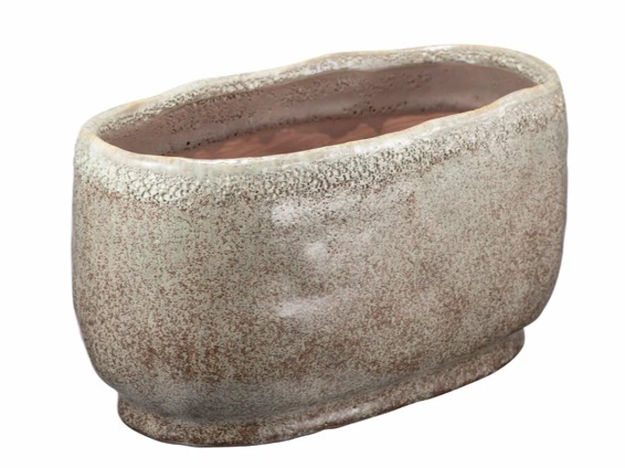 Oval formet keramisk krukke med en grov, spættet beige og brun tekstur, let ujævn kant og blank indre overflade.