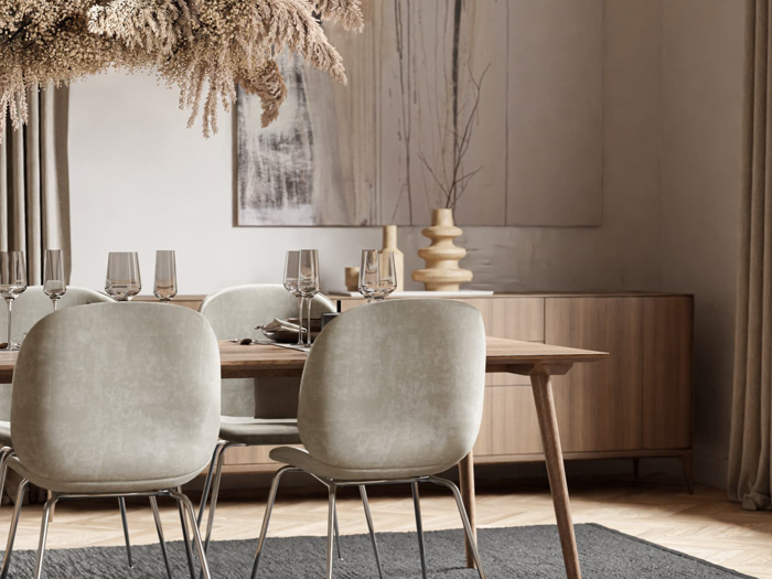 Moderne spisestue med lysegrå stole, et træbord med glas, tørrede blomsterarrangementer over hovedet og minimalistisk indretning med vaser og abstrakt vægkunst i neutrale toner.