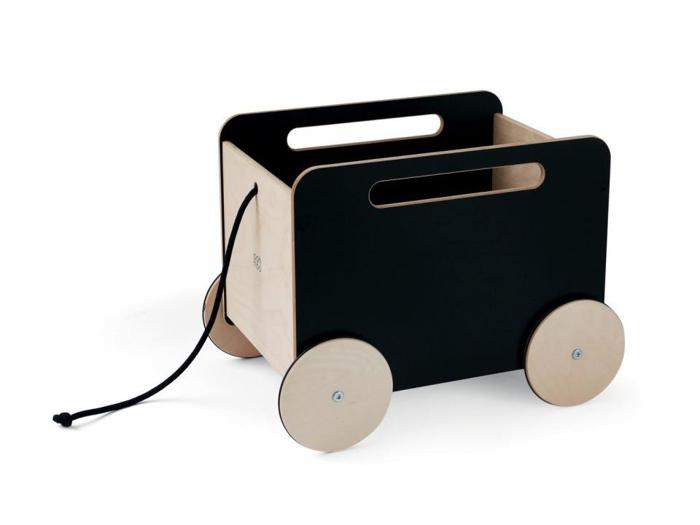 En legetøjsvogn af træ med fire lyse hjul, sorte sider, udskårne håndtag og en træksnor foran.