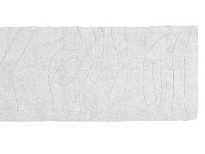 Et rektangulært hvidt tæppe med et subtilt, hævet mønster, der ligner trækorn.