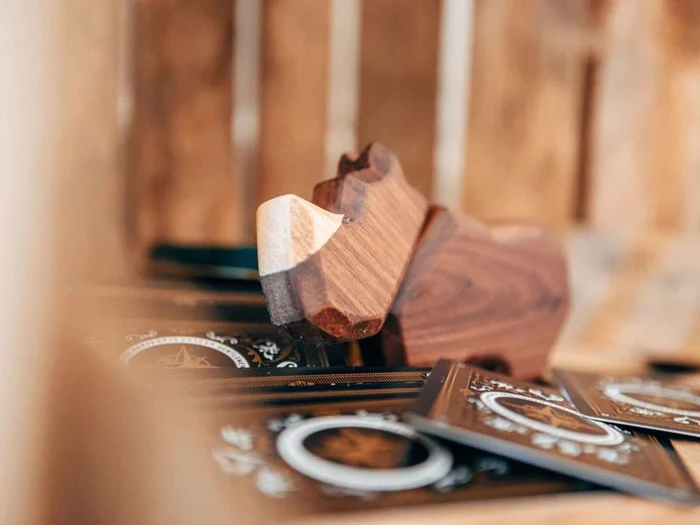 En træfigur formet som et næsehorn er udstillet blandt kunstfærdigt designede kort med cirkulære mønstre.