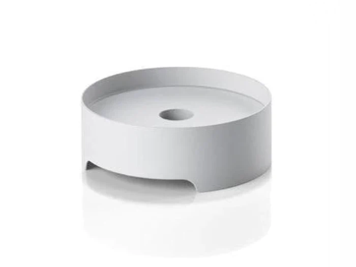 En rund, hvid, forhøjet platform med et centralt hul og åbne sider, placeret på en hvid overflade.