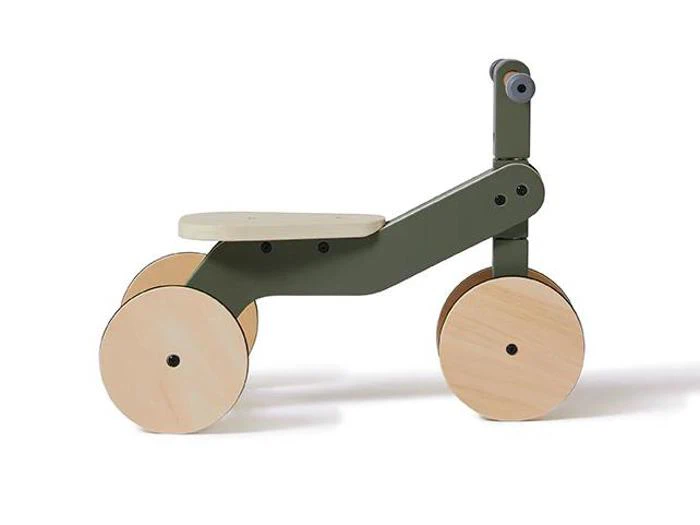 En minimalistisk løbecykel i træ til børn med hjul og sæde i lyst træ og et mørkegrønt stel, vist på en hvid baggrund.