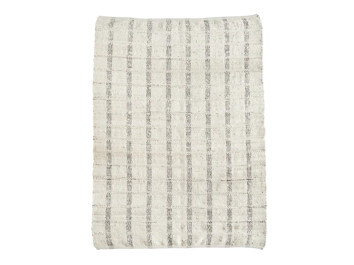 Et rektangulært cremefarvet tæppe med et diskret gråt ternet mønster på en hvid baggrund.
