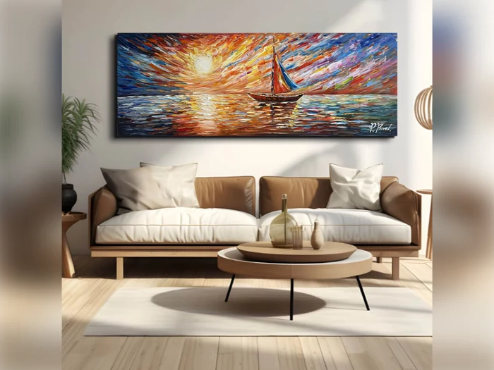 En moderne stue med en beige sofa og et rundt sofabord, hvor der på væggen over sofaen hænger et farvestrålende maleri af en sejlbåd på vandet ved solnedgang.