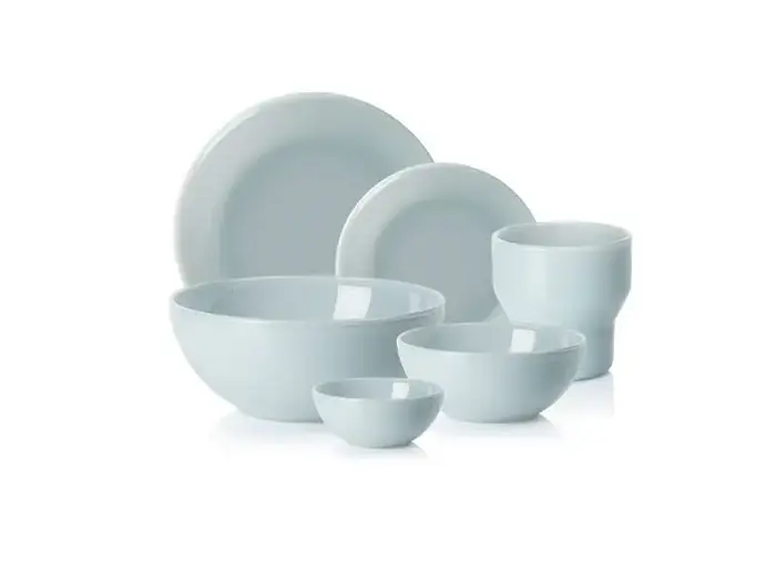 Et sæt med seks ensfarvede hvide keramikfade, herunder tallerkener, skåle og en kop, arrangeret på en hvid baggrund.
