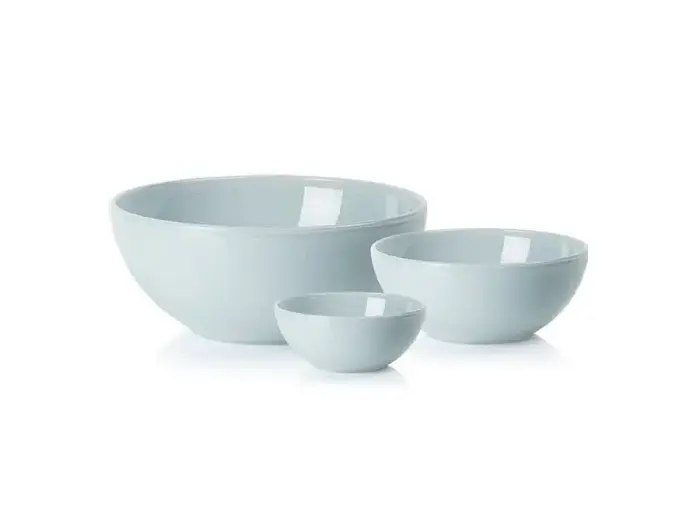 Tre lyseblå keramikskåle i forskellige størrelser er placeret ved siden af hinanden på en hvid baggrund.
