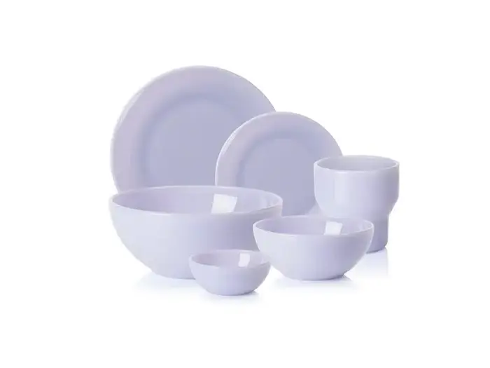 Et sæt hvide keramikfade med to tallerkener, to skåle og to kopper, arrangeret på en hvid baggrund.