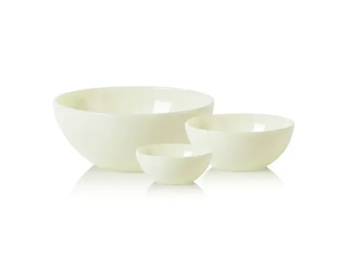 Tre hvide keramiske røreskåle i forskellige størrelser arrangeret på en hvid overflade med hvid baggrund.