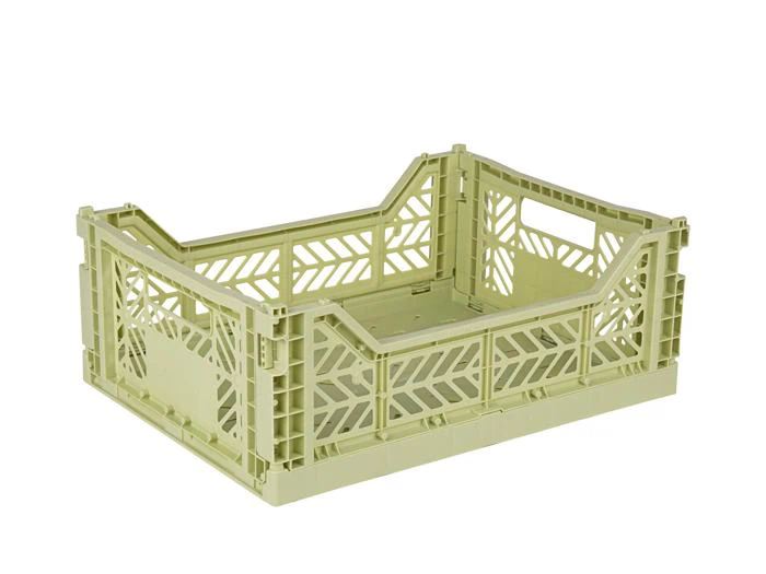 Lysegrøn plastkasse med åben top og udskåret geometrisk mønster på siderne, designet til opbevaring eller transport.