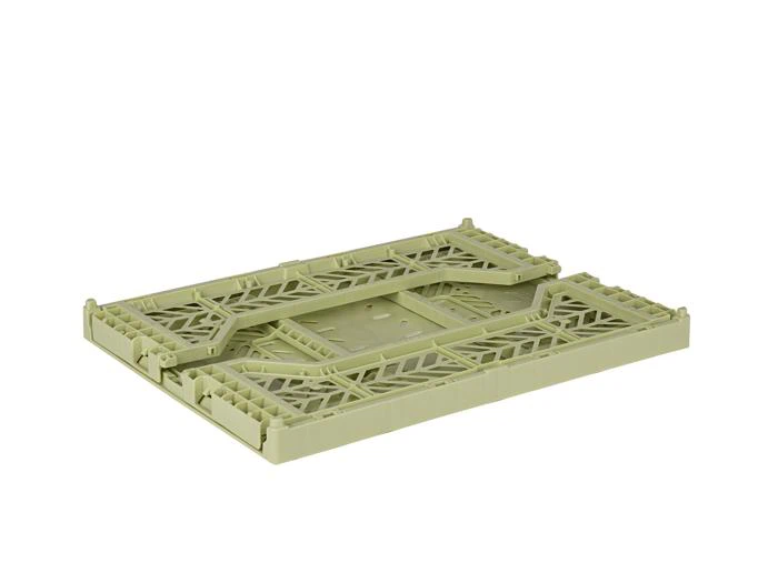 En flad, lysegrøn, rektangulær plastbakke med et geometrisk udskæringsmønster og hævede kanter, fotograferet på en hvid baggrund.