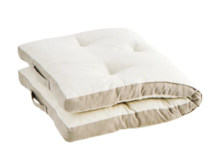 En foldet, tyk, hvid rullemadras med beige sider og stofhåndtag, placeret på en hvid baggrund.