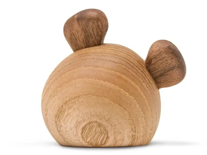 En rund, glat træfigur med to mindre, mørkere træstykker, der ligner ører, på toppen mod en hvid baggrund.