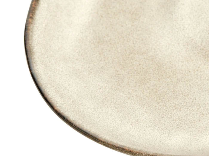 Et nærbillede af kanten på en rund, beige keramiktallerken med en let struktureret overflade og en tynd, mørk kant.