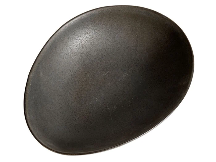 En stor, oval, mørkegrå keramiktallerken med en glat, mat finish, fotograferet mod en hvid baggrund.