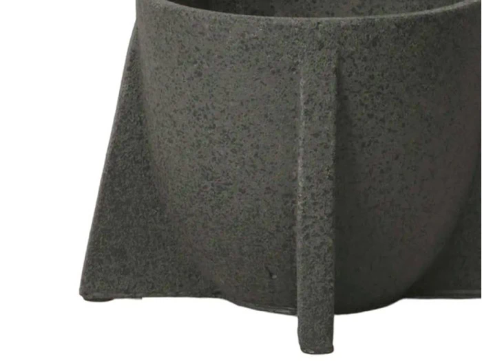 Nærbillede af en struktureret, mørkegrå, geometrisk krukke med afrundet krop og kantet base mod en hvid baggrund.