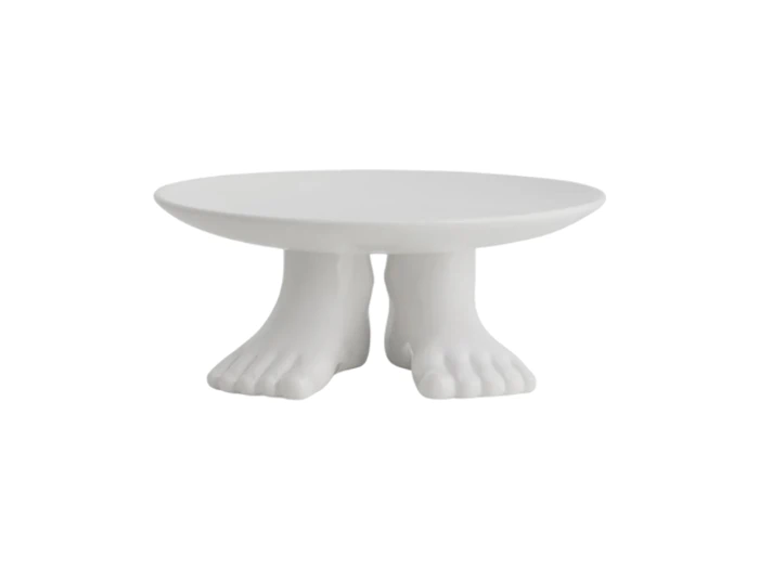 Et rundt hvidt bord med to skulpturelle fødder som base, hvilket giver indtryk af, at bordet står på menneskefødder.