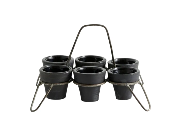 Seks små sorte gryder anbragt i en metalholder med håndtag, isoleret på en hvid baggrund.