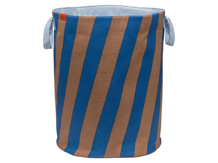 En cylindrisk vasketøjskurv af stof med blå og brune diagonale striber og to lyseblå hanke.