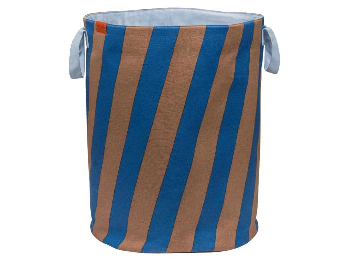 En cylindrisk vasketøjskurv af stof med blå og brune diagonale striber og to lyseblå hanke.