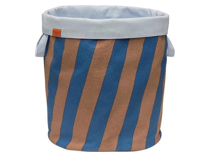 En opbevaringskurv af stof med lodrette blå og brune striber, hvid kant øverst og to håndtag i siden.