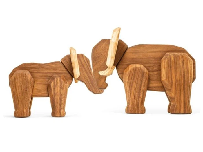 To elefantfigurer af træ, en større og en mindre, står side om side med front mod hinanden. Begge har lyse stødtænder og er udformet med enkle geometriske former.
