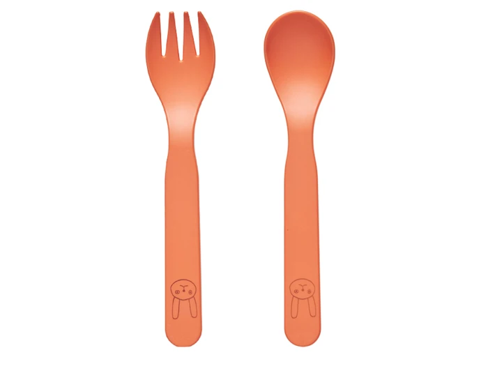 To orange bestikdele, en spork og en ske, begge med en enkel tegning af et kaninansigt på skaftet, placeret side om side på en hvid baggrund.