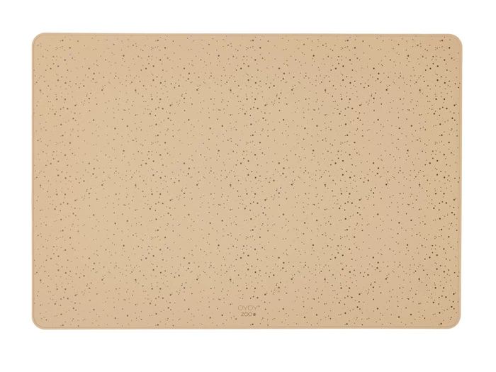 En rektangulær, beige dækkeserviet med små sorte prikker og afrundede hjørner på hvid baggrund.