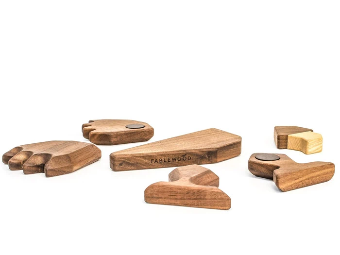 Seks dele af legetøjsdyr i træ med glat overflade og afrundede kanter, adskilt og anbragt på en hvid baggrund. Midterstykket er mærket Fablewood.