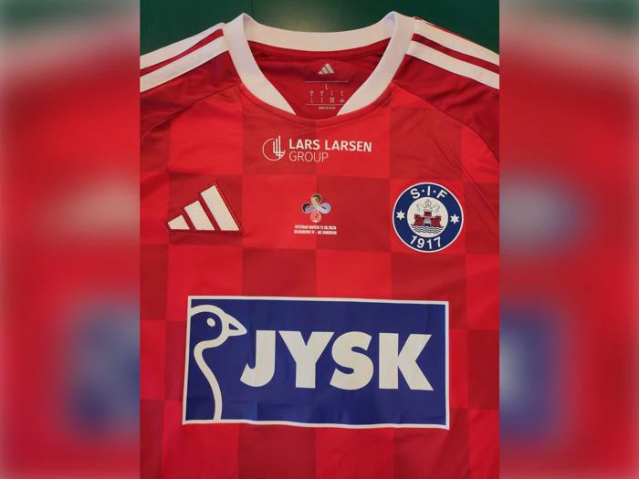 Rød Silkeborg IF-fodboldtrøje med JYSK-logoet, Lars Larsen Group-logoet og et emblem for Veteran Match-arrangementet.