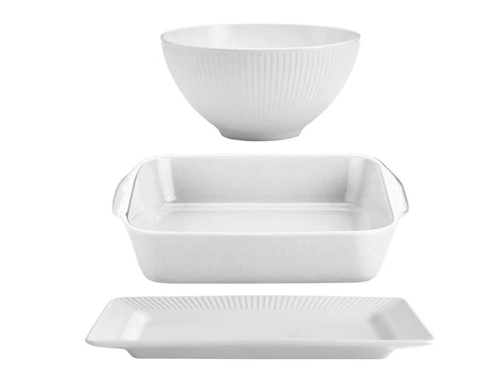 Tre hvide keramikfade: en rund skål øverst, et rektangulært bagefad med håndtag i midten og en rektangulær tallerken nederst, alt sammen på en hvid baggrund.