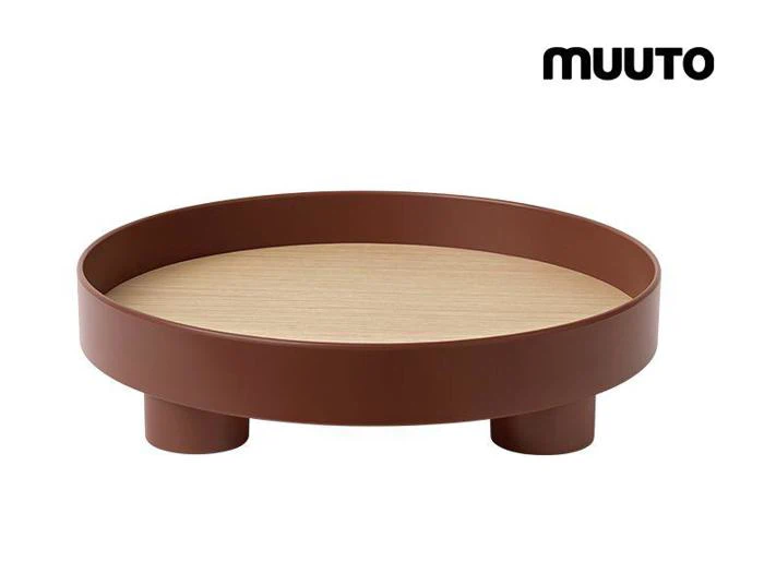 En moderne, rund bakke med en lys træoverflade og hævet brun kant, støttet af tre cylindriske ben. Ordet MUUTO står i øverste højre hjørne.