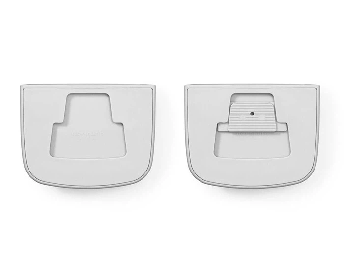 To hvide plastikstykker, hver med en let buet rektangulær form og udskårne sektioner, vist side om side mod en hvid baggrund.