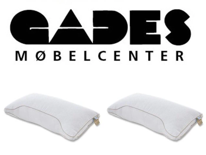 Logo med teksten GADES MØBELCENTER over to hvide rektangulære puder på en ensfarvet baggrund.