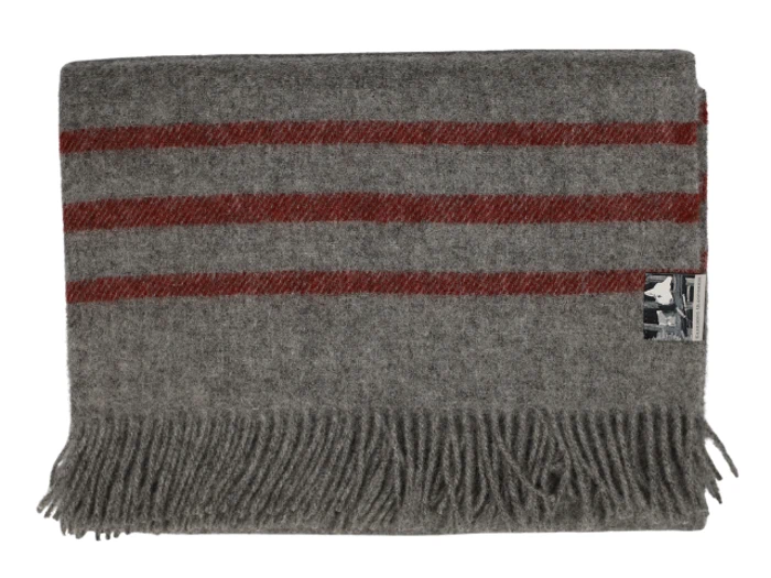 Et foldet gråt uldtæppe med tre vandrette røde striber og frynsede kanter. En lille etiket er fastgjort til det ene hjørne.