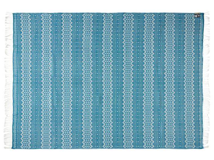 Et rektangulært blåt vævet tæppe med hvide geometriske og zigzagmønstre, afsluttet med hvide frynser på de korte kanter.