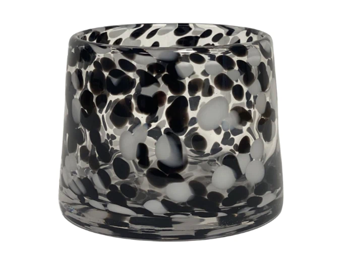 Et klart glasbæger med en konisk form, dekoreret med sorte og hvide pletter på hele overfladen.