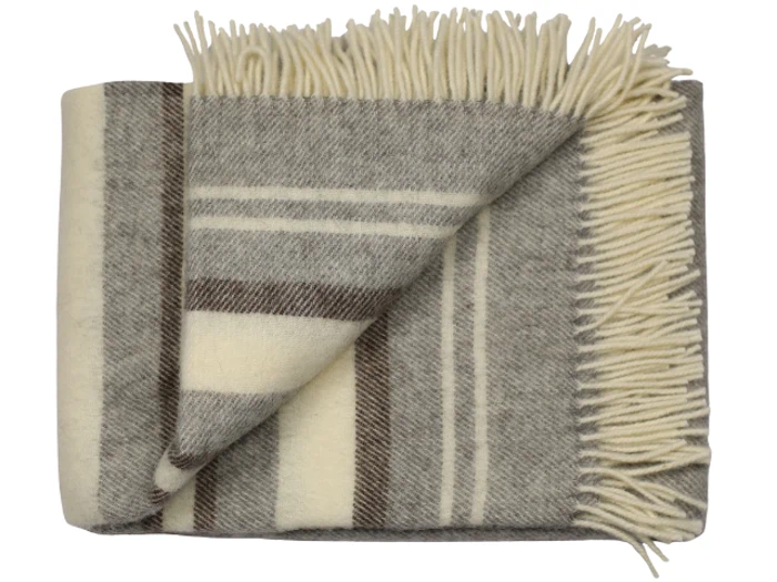 Et foldet uldtæppe med cremefarvede, grå og brune striber og cremefarvede frynser langs kanten.