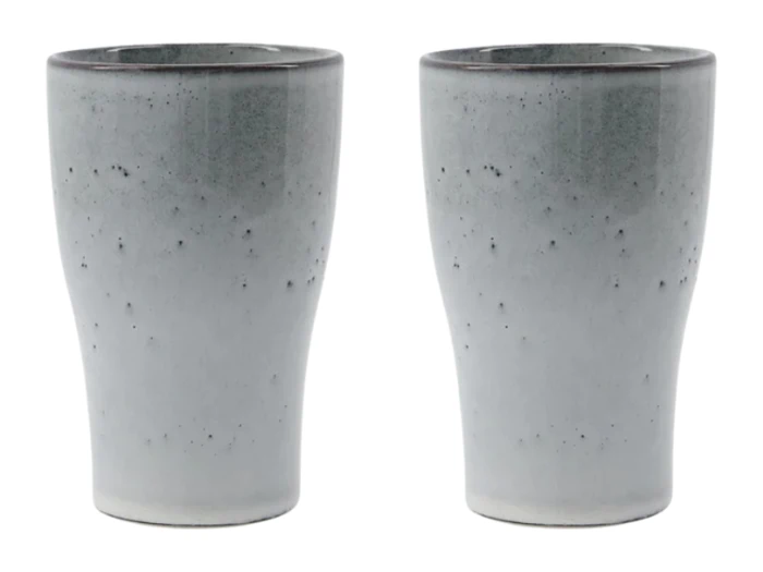 En blågrøn legetøjstromme med to trommestikker, to grønne maracas og fire kapselformede legetøjsshakere i forskellige farver på en hvid baggrund.