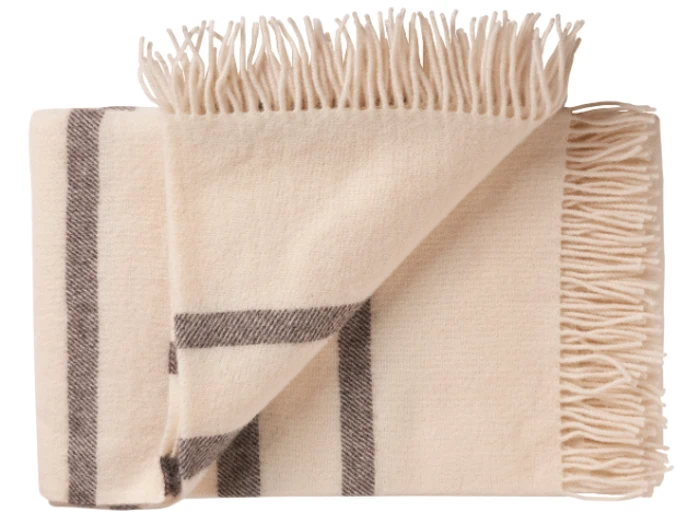 Et foldet cremefarvet tæppe med mørkebrune striber og frynsede kanter.