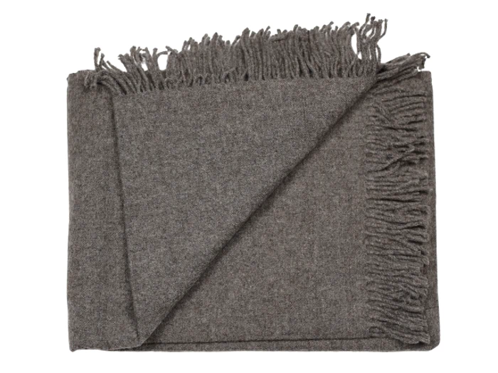Et gråt foldet uldtæppe med frynsede kanter, sirligt arrangeret på en hvid baggrund.