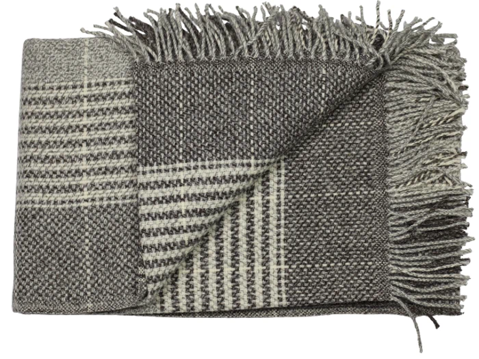 Et foldet, vævet tæppe med et ternet mønster i grå og creme og frynsede kanter.