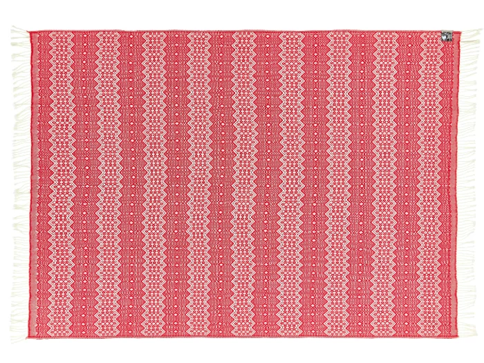 Et rektangulært rødt og hvidt mønstret vævet tæppe med indviklede geometriske mønstre og hvide frynser på de korte kanter.