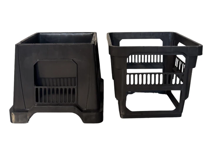 To sorte mælkekasser af plast er placeret side om side på en hvid baggrund, den ene kasse er opretstående og solid, mens den anden er åben med sprækker i sider og bund.