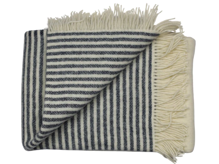 Et foldet, frynset tæppe med marineblå og hvide diagonale striber på den ene side og ensfarvet creme på den anden.