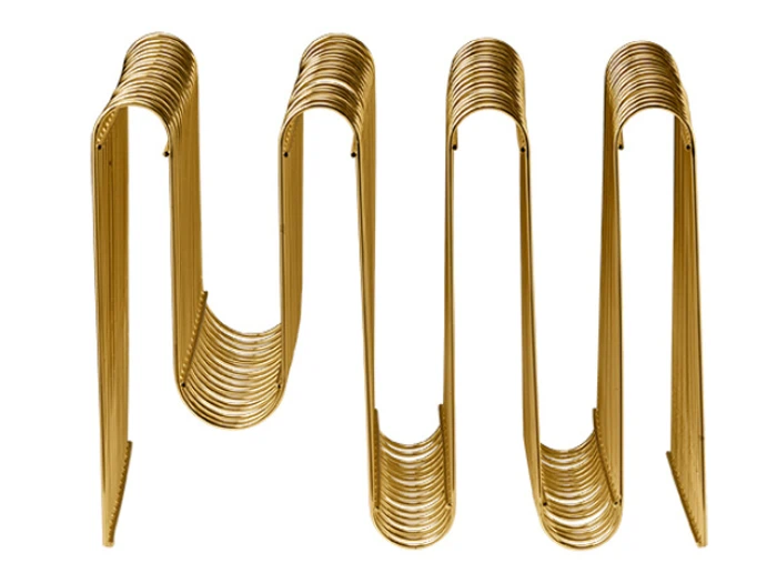En guldfarvet, bølget magasinholder i metal med et moderne, harmonikaagtigt design set ovenfra.