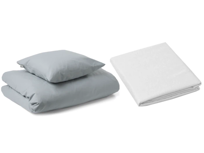 En foldet lysegrå dyne og pude er stablet til venstre ved siden af et pænt foldet hvidt lagen til højre, alt sammen på en hvid baggrund.