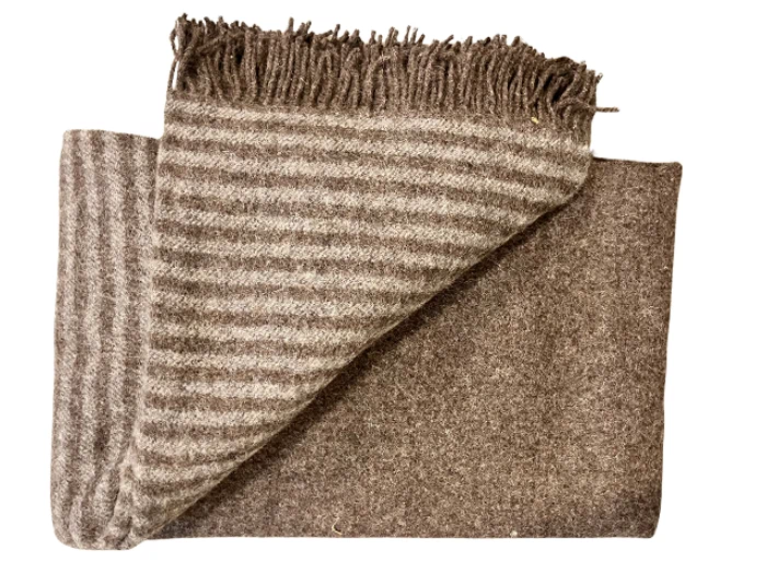 Et foldet brunt uldtæppe med frynser, hvor den ene side er ensfarvet brun og den anden har lyse- og mørkebrune striber.
