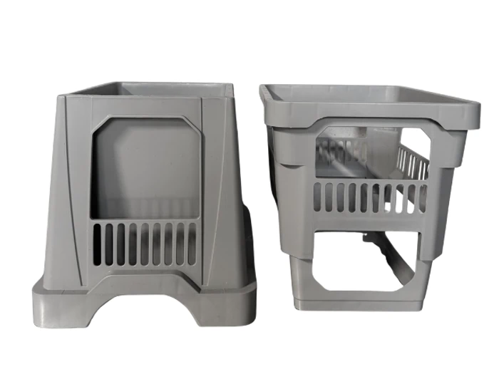 To grå bestikkurve af plast til opvaskemaskine med åbne åbninger og rum, vist side om side på en almindelig hvid baggrund.