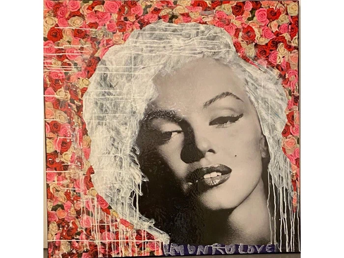 Et gråt plysdyr med store ører, set bagfra, iført en rød- og pinkstribet strikkjole og stående på en hvid baggrund.